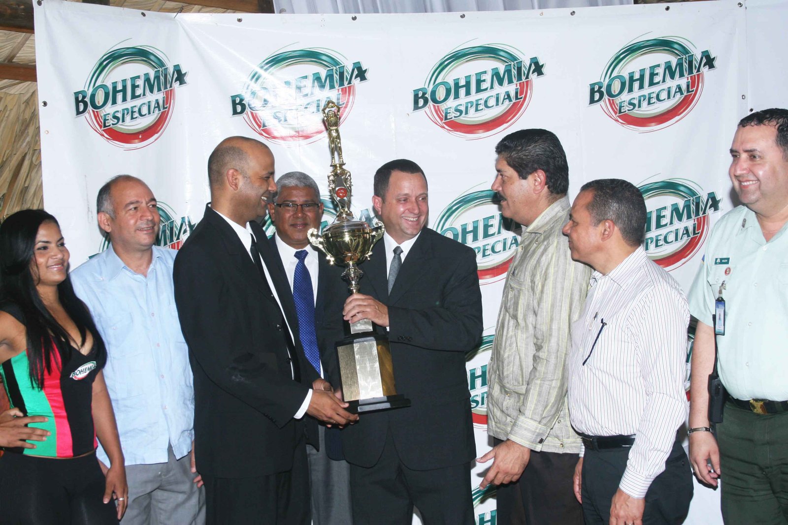 El ejecutivo de la Cervecería Nacional Dominicana Cesar Ureña entrega el trofeo a los organizadores del superior de Moca.